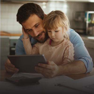 man and child viewing tablet device