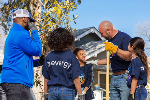Volunteers and children planting trees together