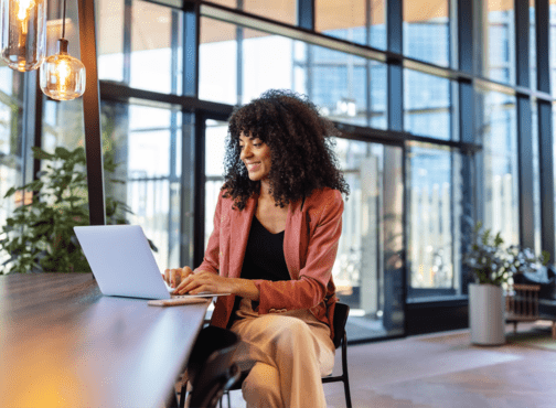 A woman sitting at a table using online tools to check her energy usage